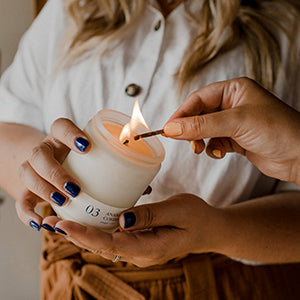 femmes qui allument une chandelle de cire de soya